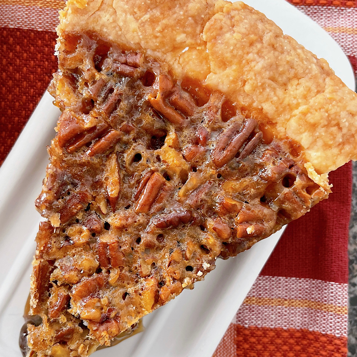 A slice of copycat Cracker Barrel Chocolate Pecan Pie on a white plate.