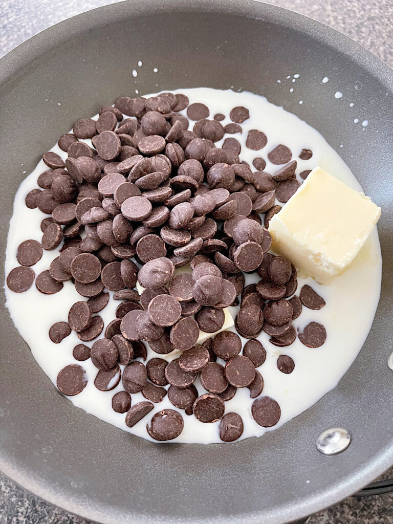 Milk, chocolate chips, and butter in a pan to make ganache.