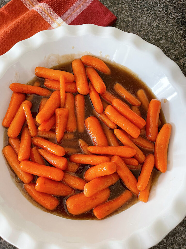 Brown sugar glazed carrots in a white dish.