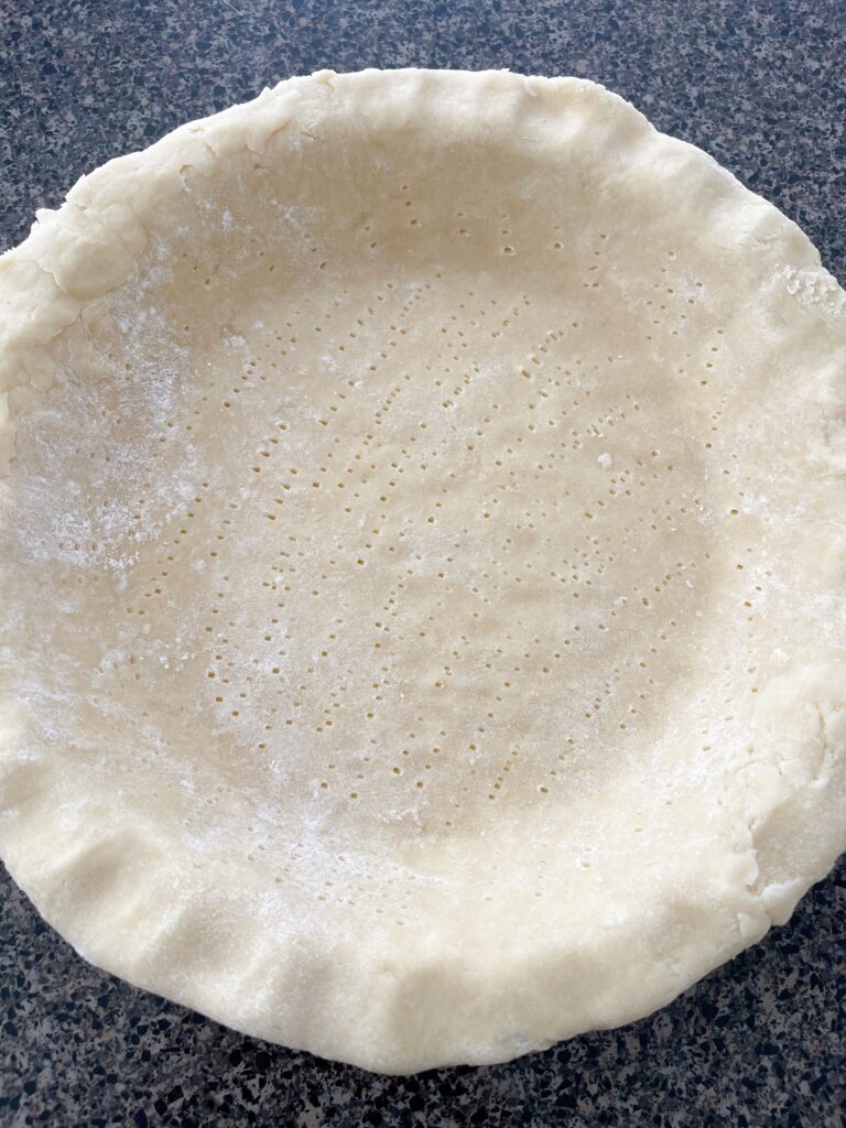 Fork pricks in an unbaked pie crust.
