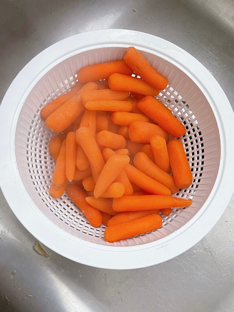 Baby carrots in a collander.