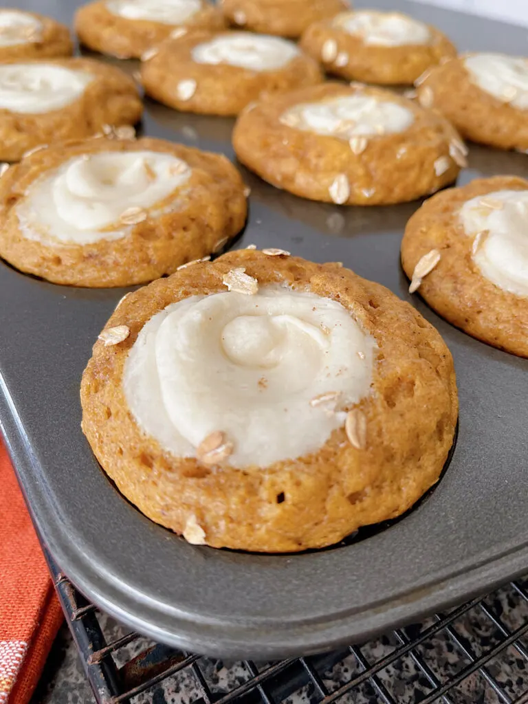 A pumpkin cream cheese muffin in a muffin pan.