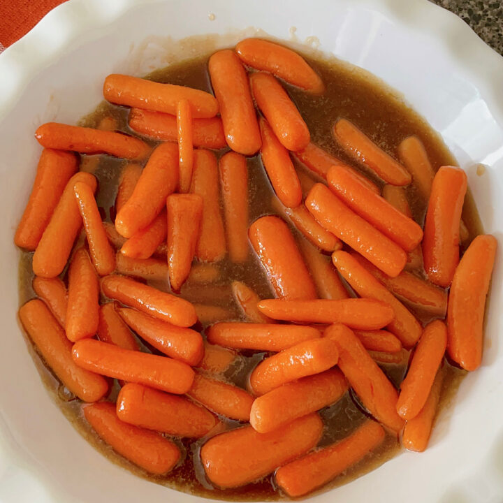 Brown sugar glazed carrots in a white dish.