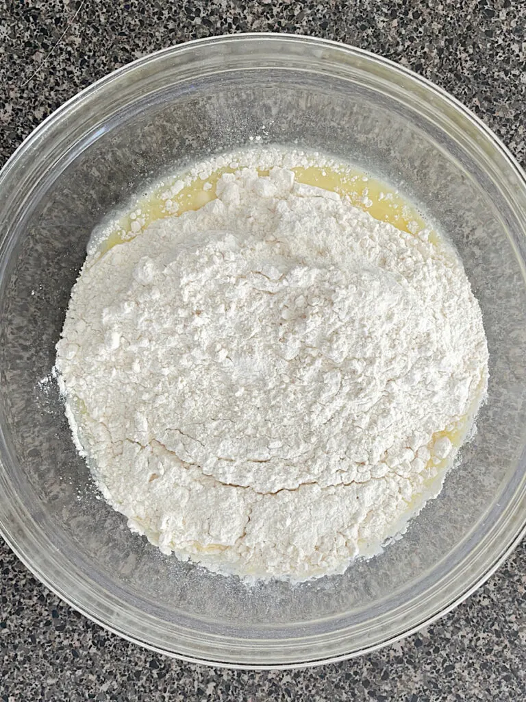 Flour, baking soda, and cream of tartar added to wet ingredients for drop scones.