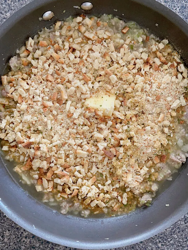 Stove Top Stuffing with sausage, onion, and celery in a pan.