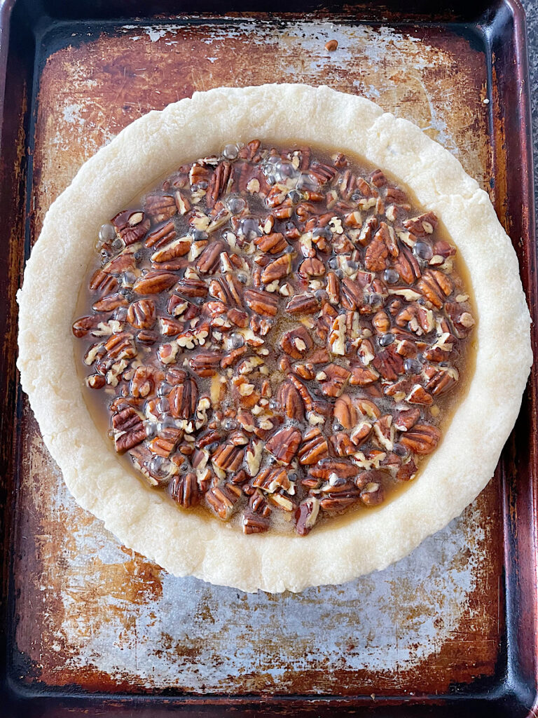 Unbaked pecan pie on a baking sheet.