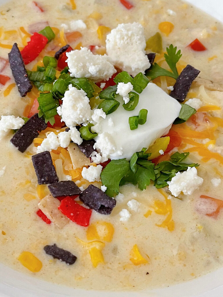 Assorted toppings on a bowl of Mexican corn chowder.