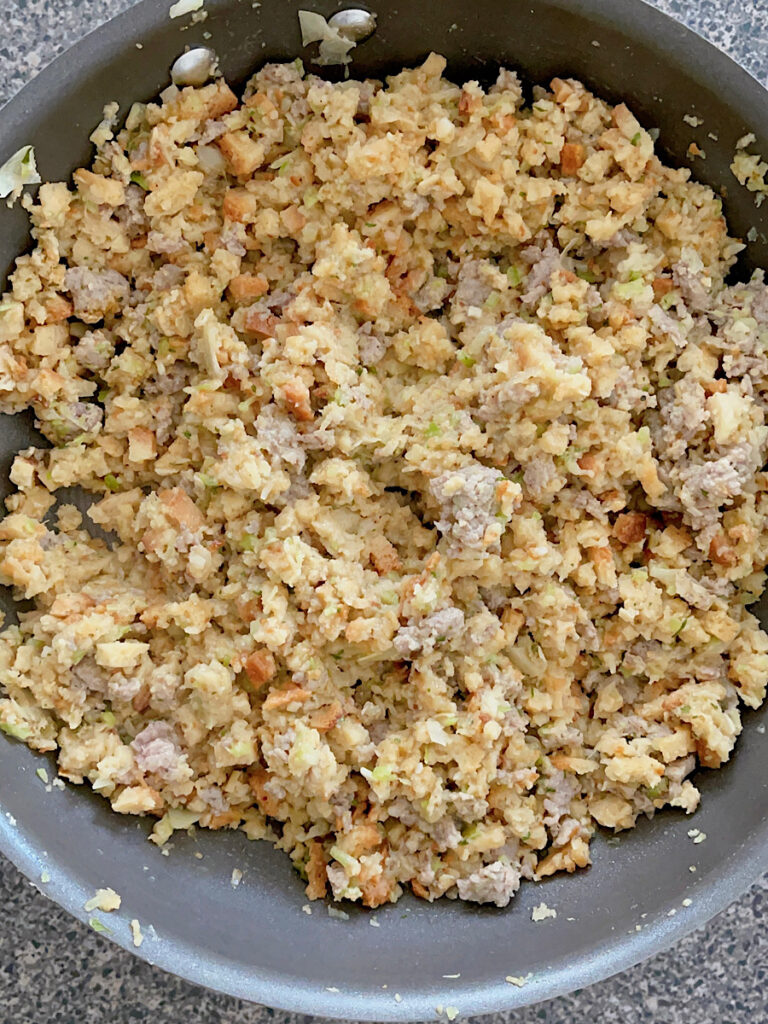 Stove Top Stuffing with sausage, onion, and celery in a pan.
