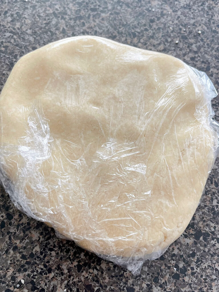 Pie crust wrapped in plastic wrap.