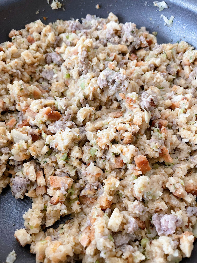 Stove Top Stuffing with sausage, onion, and celery in a pan.