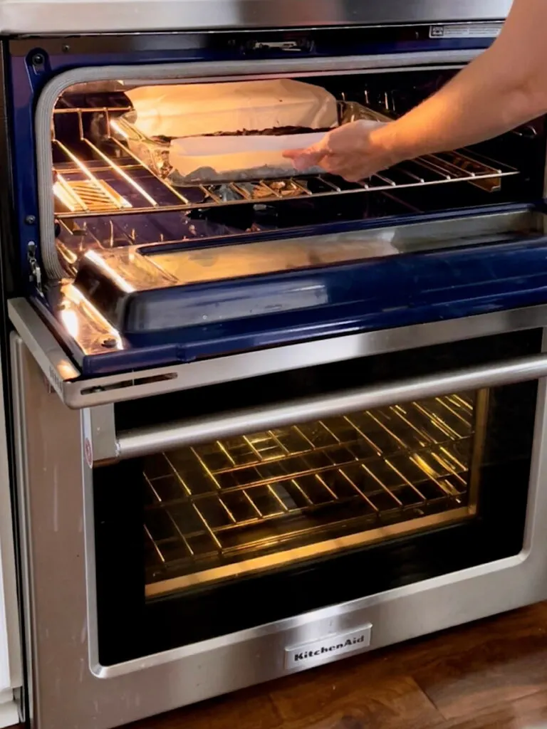 A pan of brownies being put in the oven.