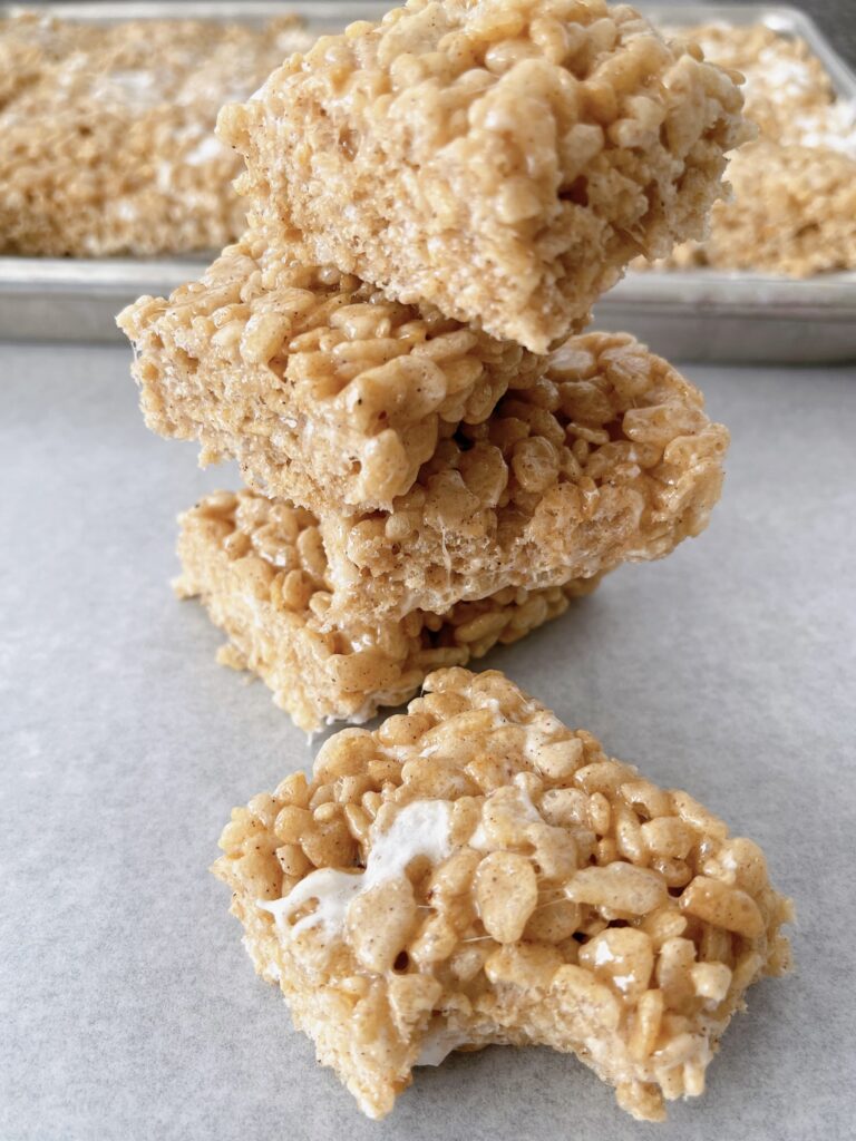 Pumpkin Rice Krispie treats cut into squares on parchment paper.