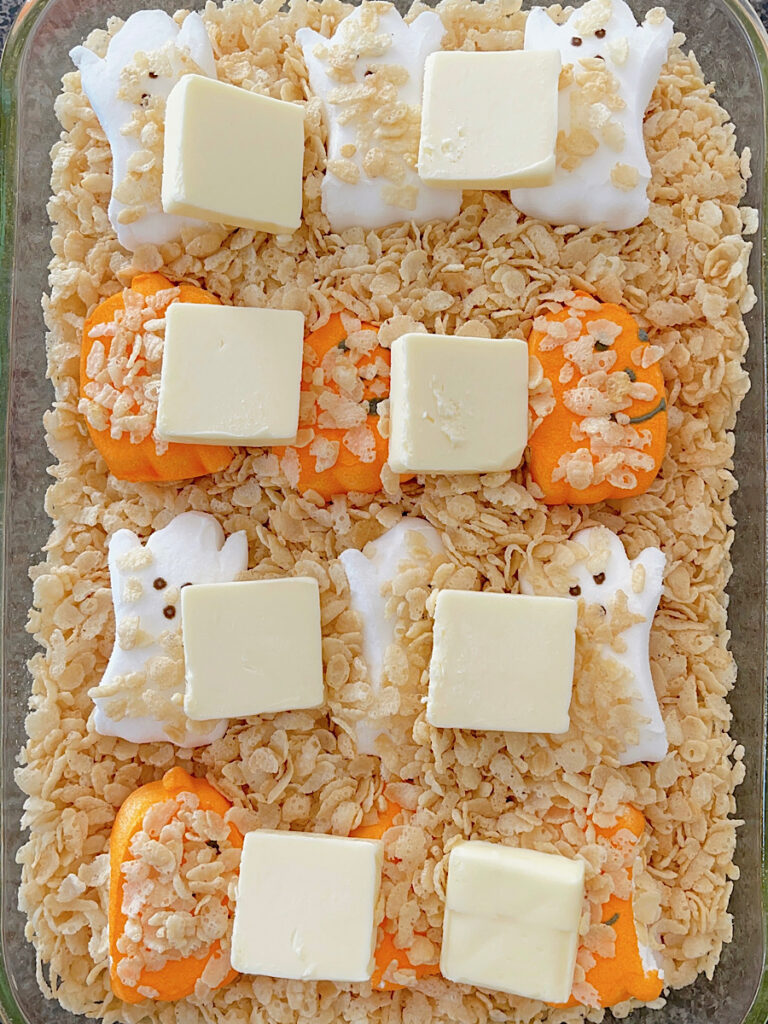 Halloween Peeps in a baking dish with Rice Krispies and butter.