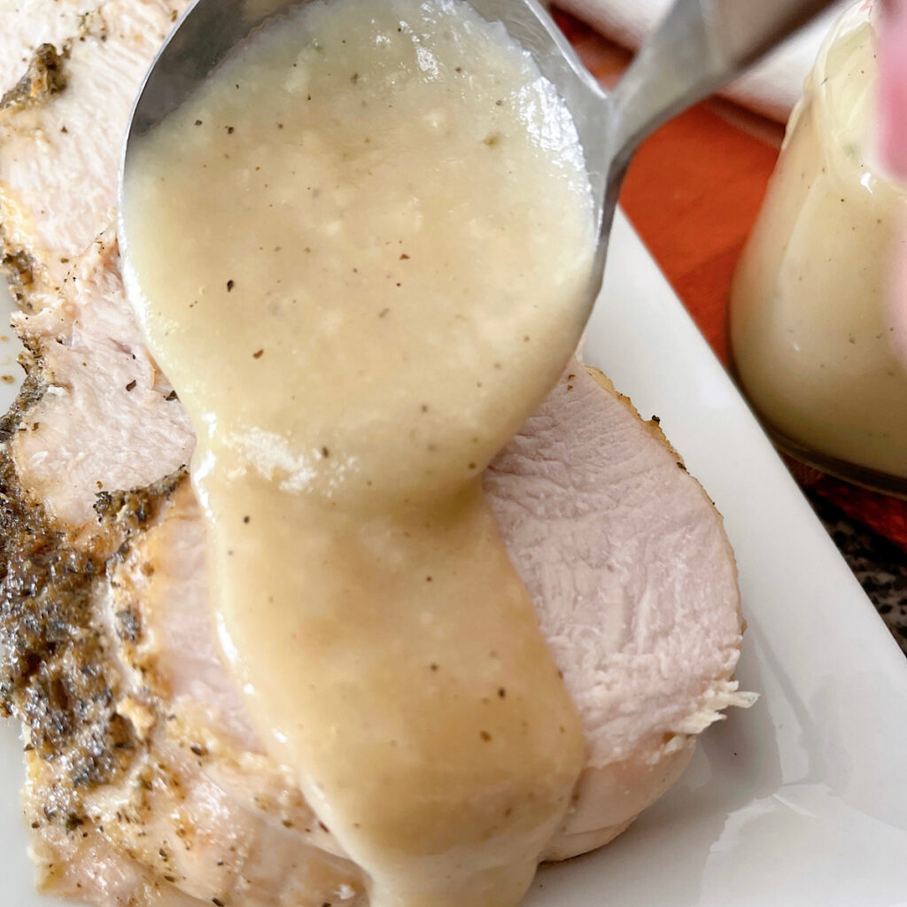 Turkey gravy spooned over a slice of turkey.