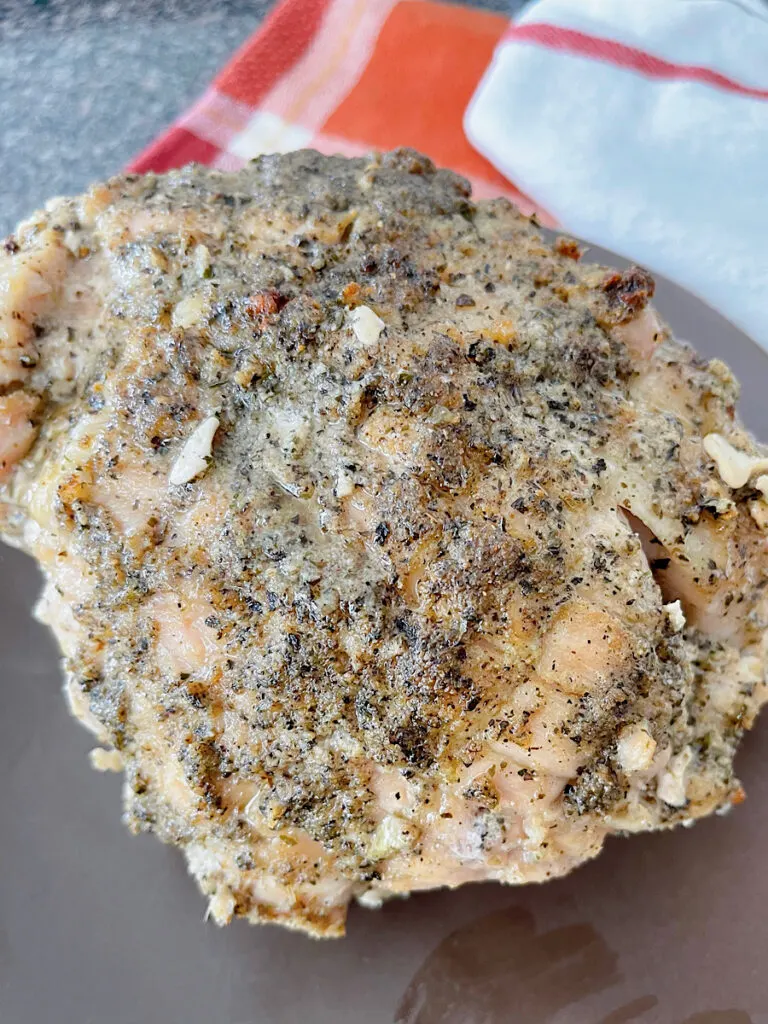 A butter & herb roasted turkey on a serving plate.