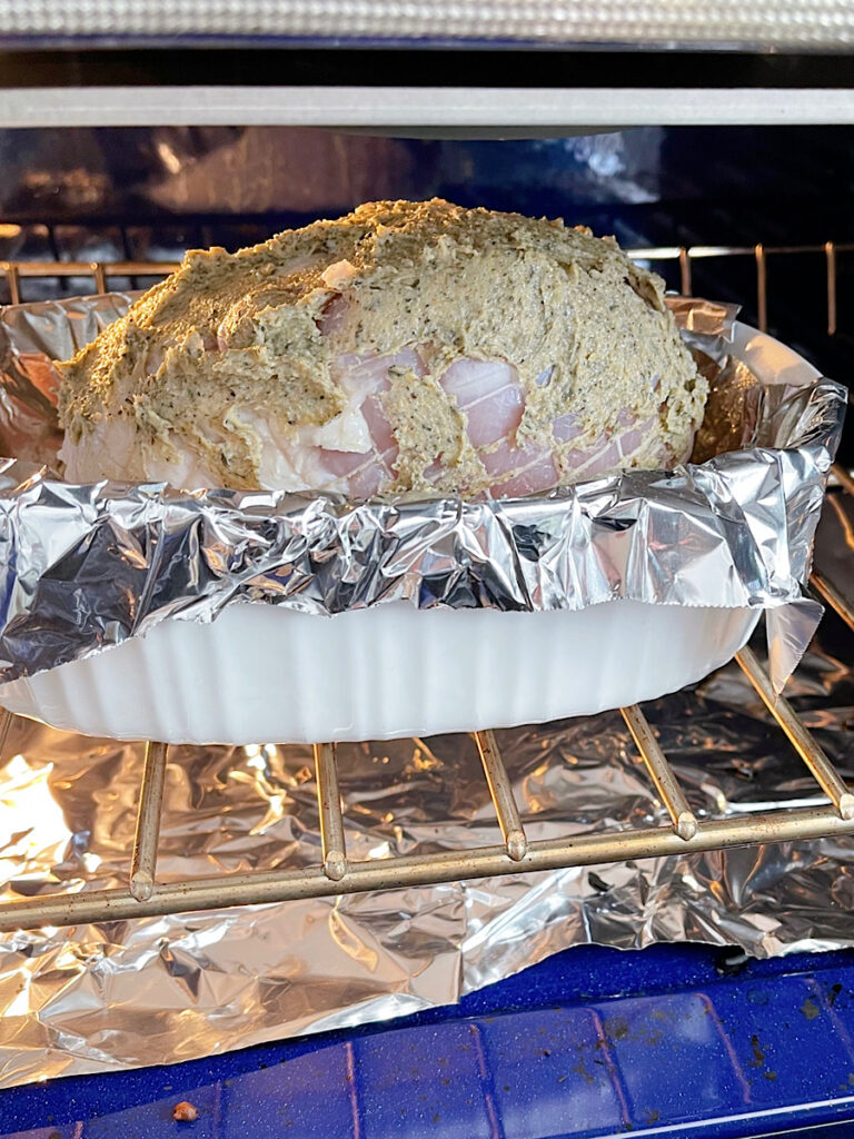 Herbs and butter spread on a turkey roasting in the oven.