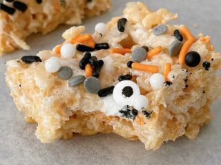 A Halloween Rice Krispie Treat with sprinkles missing a bite.