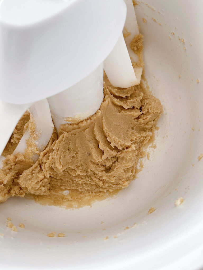 Butter mixed with sugar and brown sugar in a stand mixer.