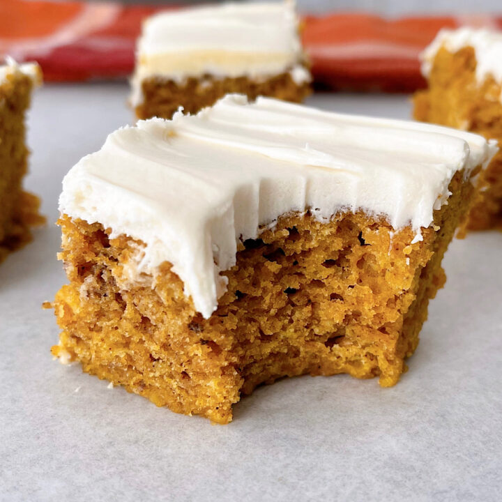 A pumpkin bar square topped with cream cheese frosting.
