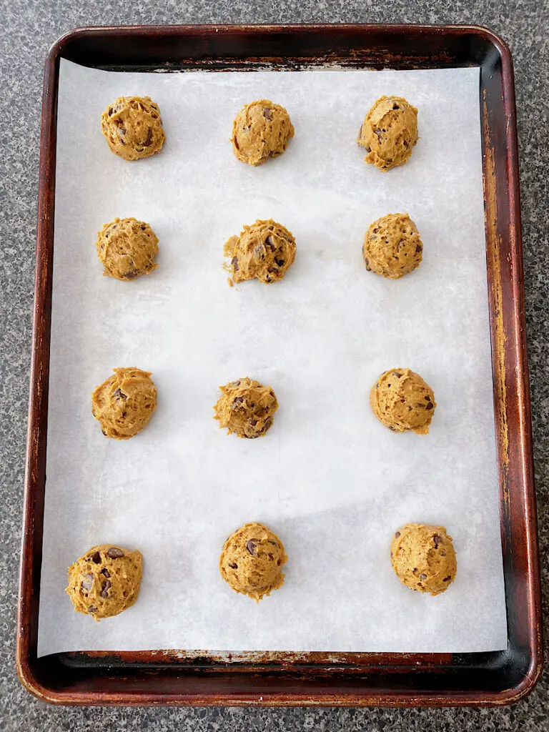 Pumpkin chocolate chip cookies on a baking sheet.