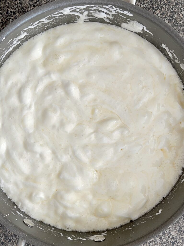 Melted butter and marshmallows in a pan to make rice Krispie treats.