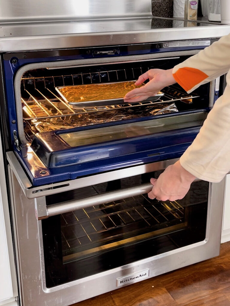 A pan of pumpkin bars being put into an oven.