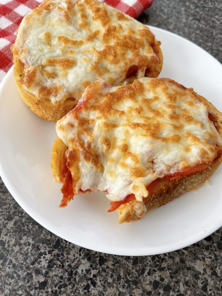 Two slices of Texas garlic toast topped with pizza sauce, pepperoni, and melted mozzarella cheese.