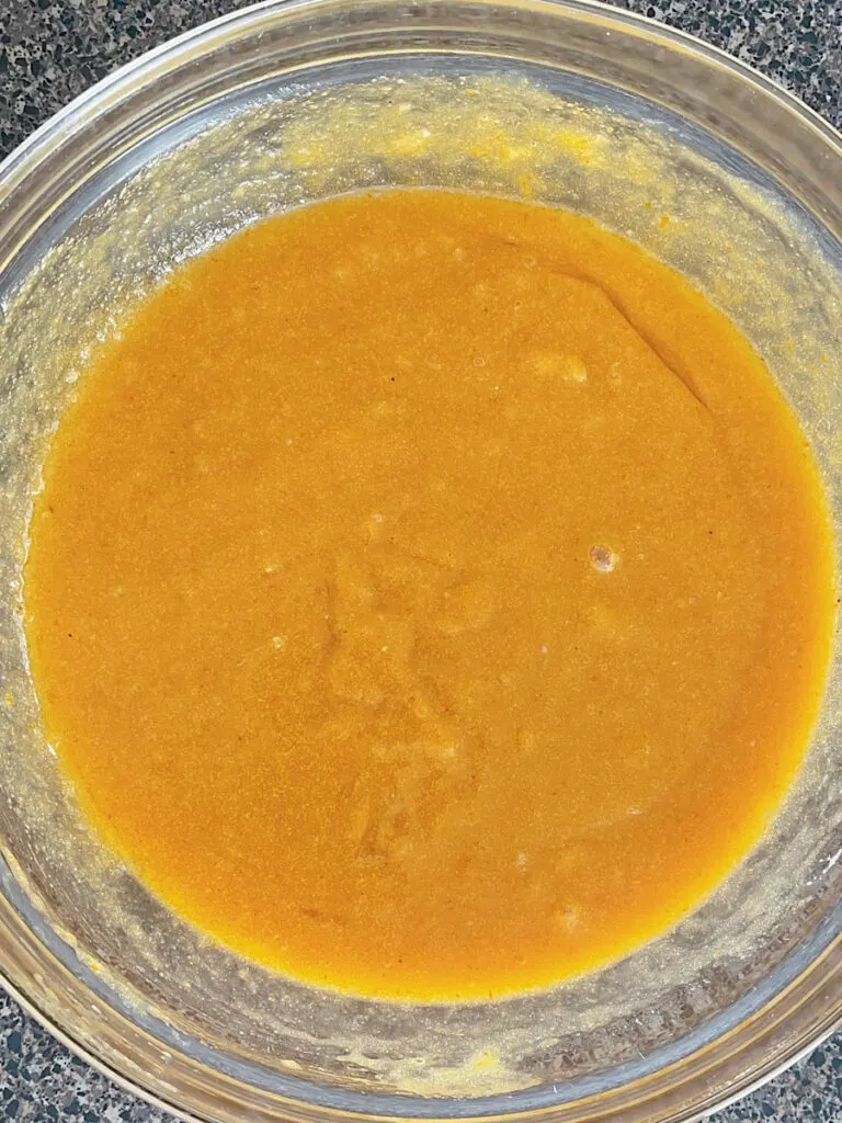 A bowl of wet ingredients for pumpkin bars.