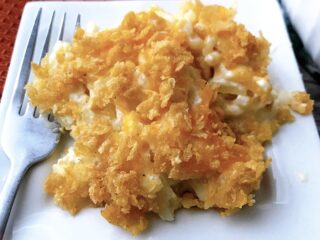 A plate of funeral potatoes on a white plate.