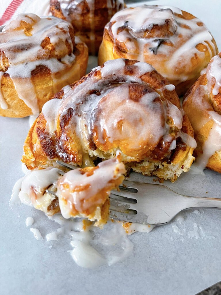 Pillsbury air fryer cinnamon rolls drizzled with icing.
