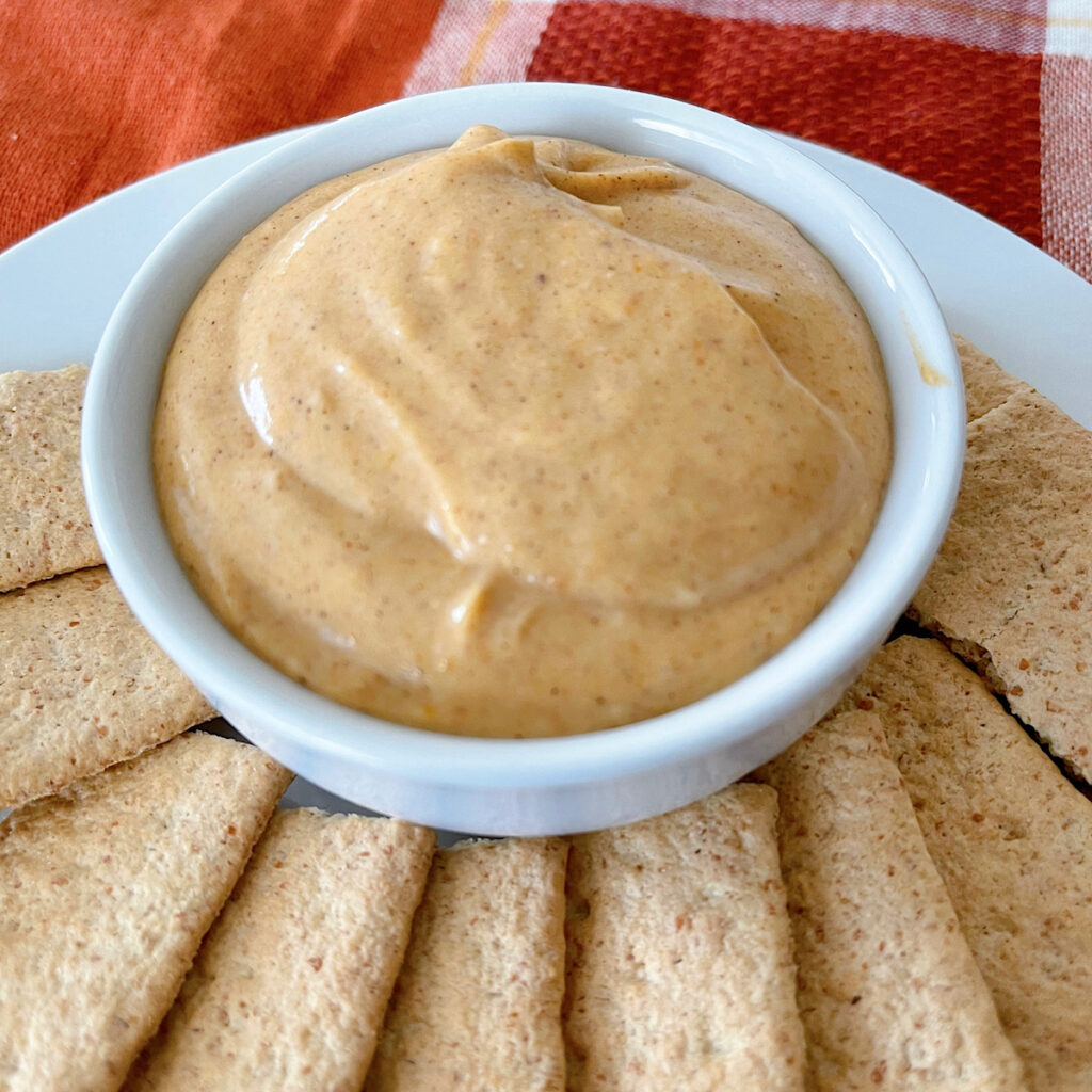 Pumpkin pie dip in a white dish with graham crackers.