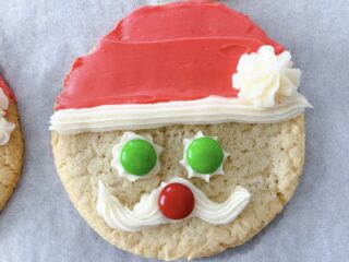 A round sugar cookie decorated to look like Santa.