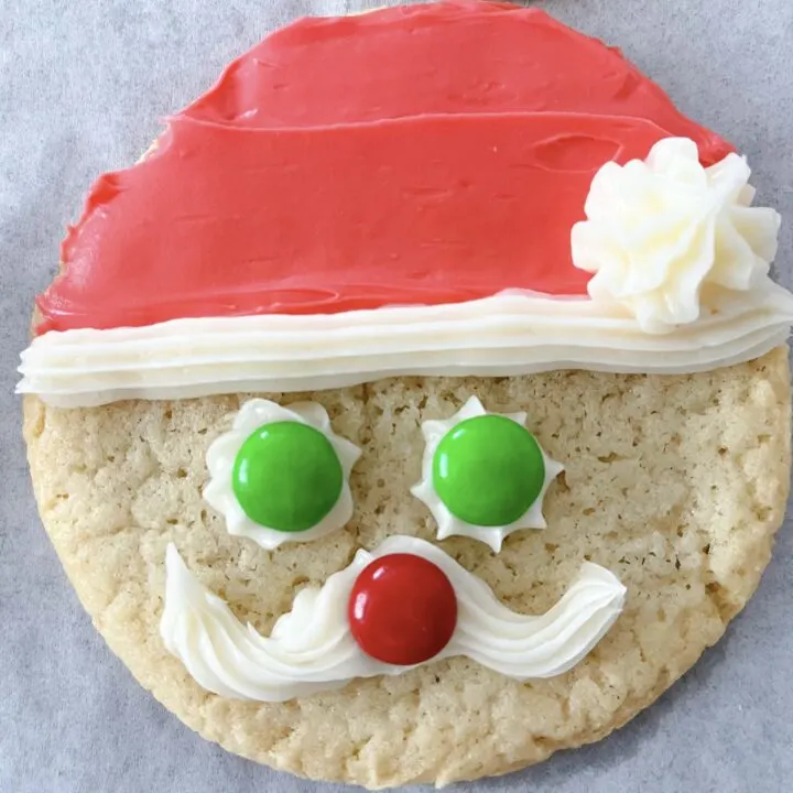 A round sugar cookie decorated to look like Santa.