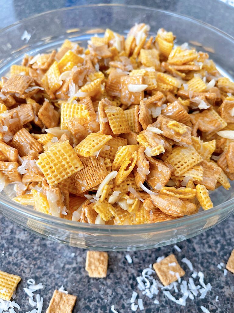 A bowl of Christmas Crack Chex Mix with Golden Grahams, Chex, coconut, and almonds.