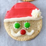 A round sugar cookie decorated to look like Santa.