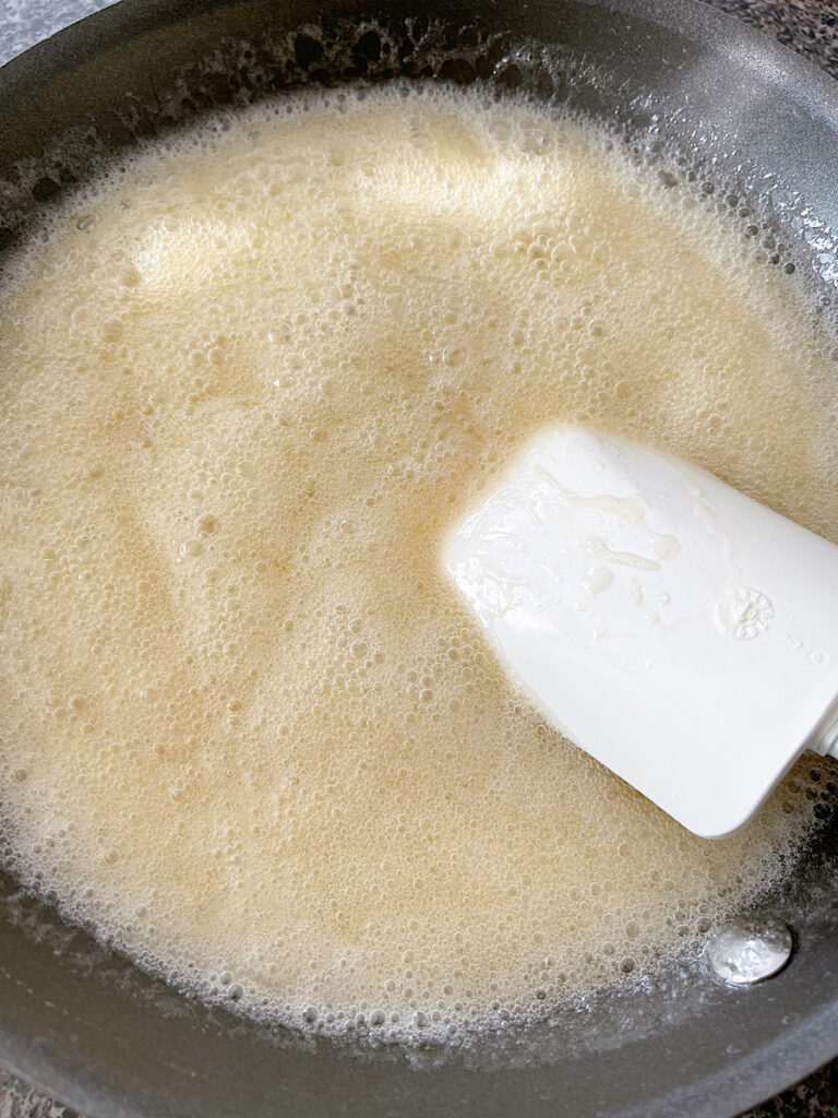 Corn syrup, butter, vanilla, and sugar boiling in a pan.