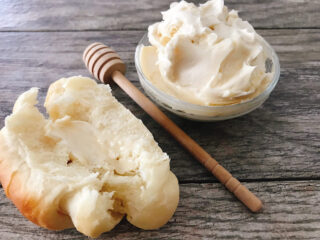 A lion house roll topped with whipped honey butter.