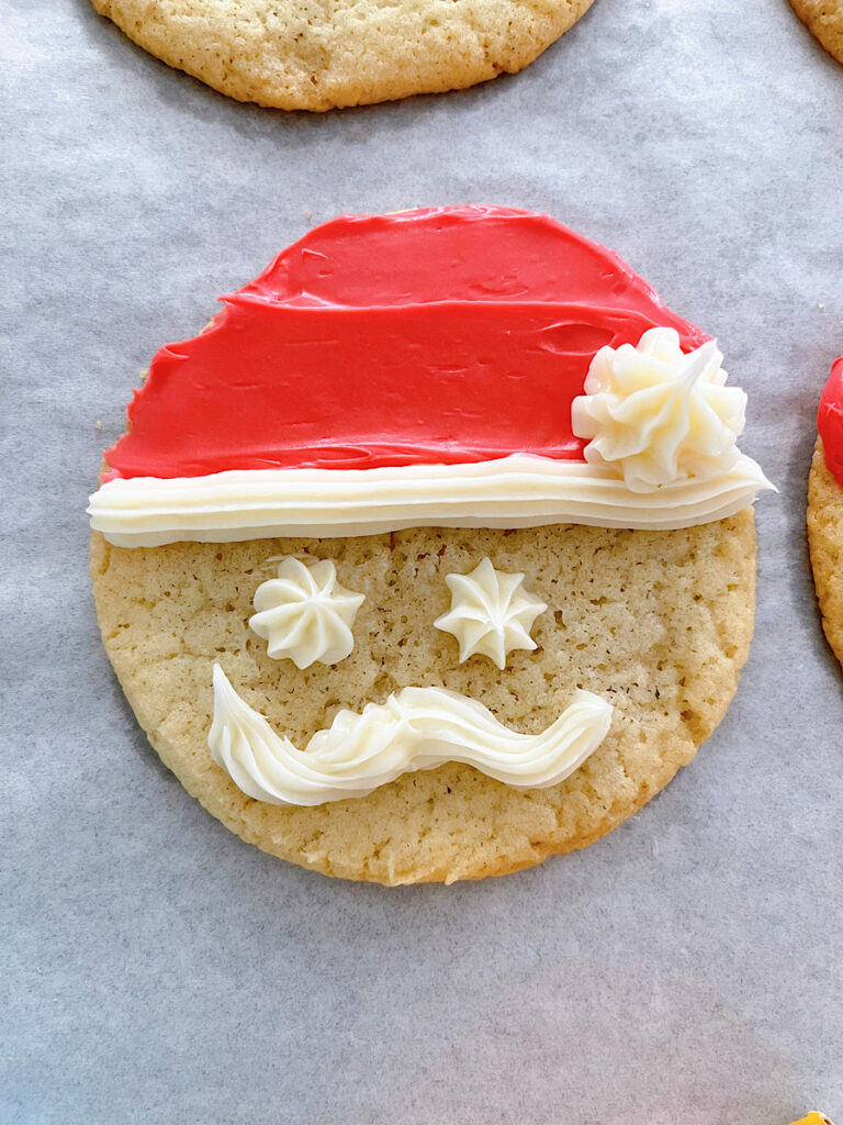 A Sugar cookie with red and white frosting to make Santa cookies.