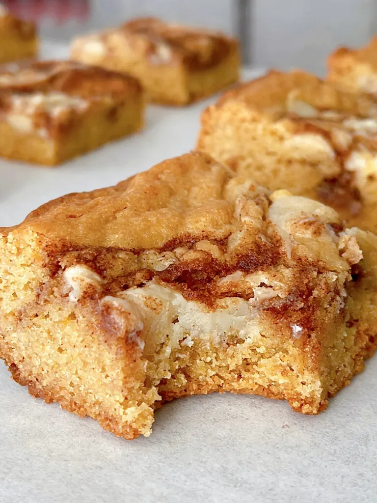 A cinnamon roll blondie missing a bite.