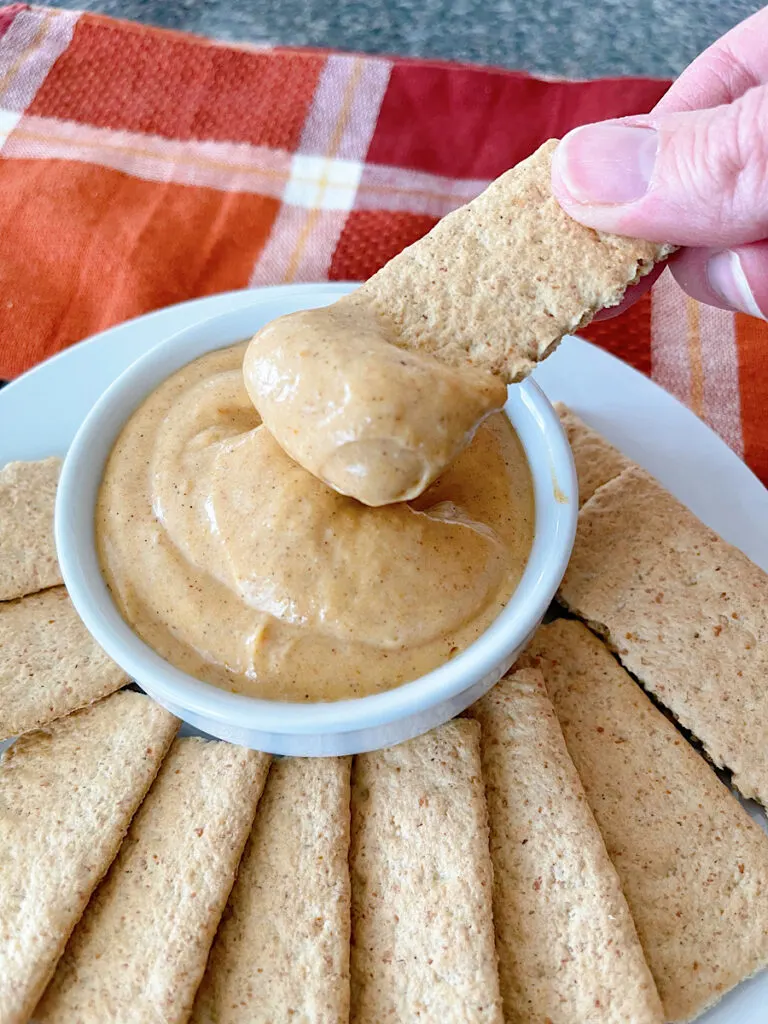 Pumpkin pie dip in a white dish with graham crackers.