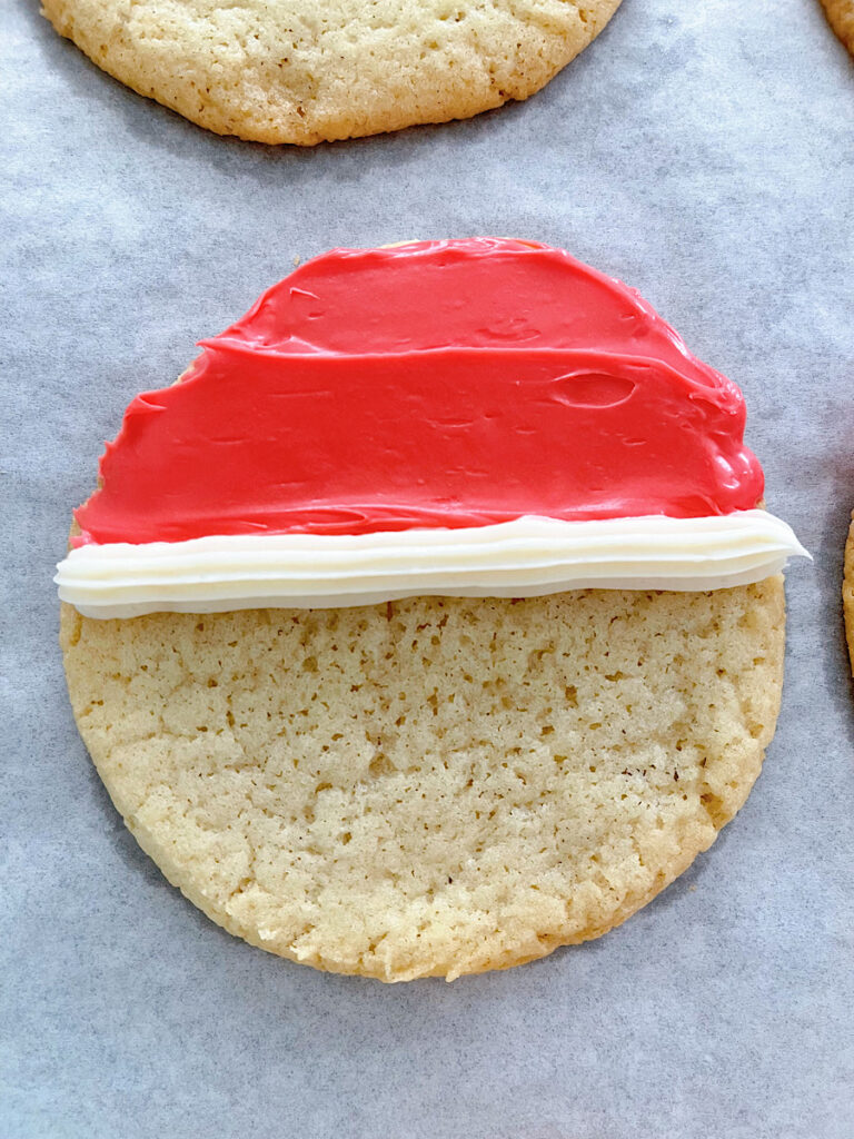 A sugar cookie with red frosting and a white line.