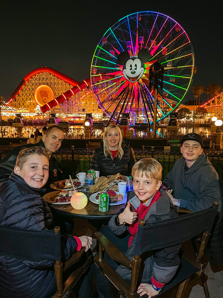 A family sitting at a table at the World of Color Dessert Party.