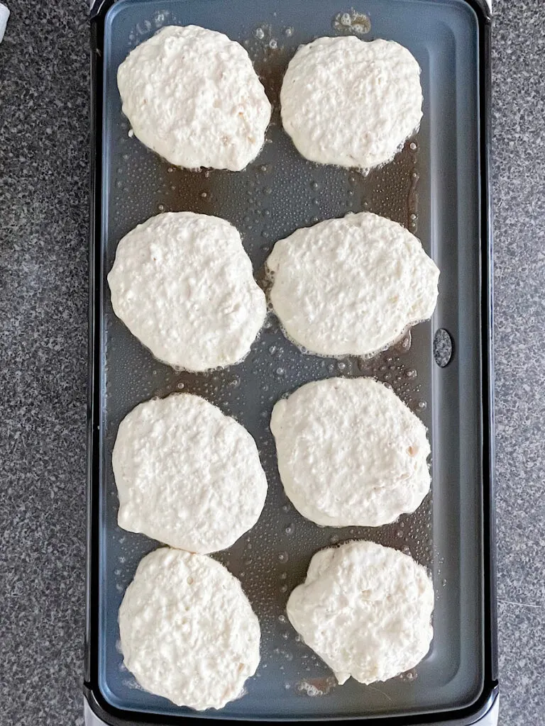 Sweet cream pancakes on a griddle.