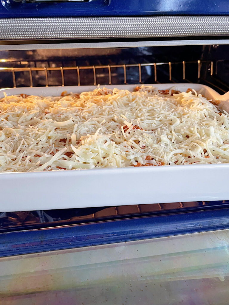 A pan of spaghetti Alfredo baking in an oven.