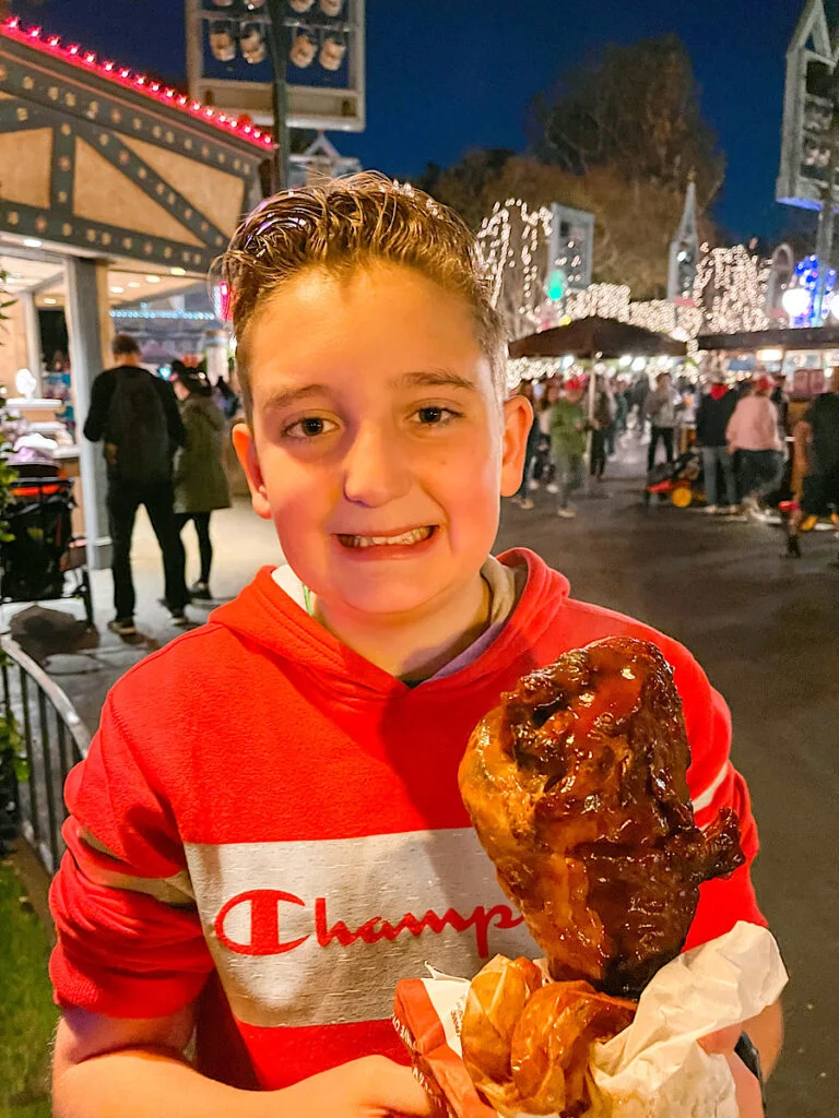 A boy with a BBQ Turkey leg at Disneyland.