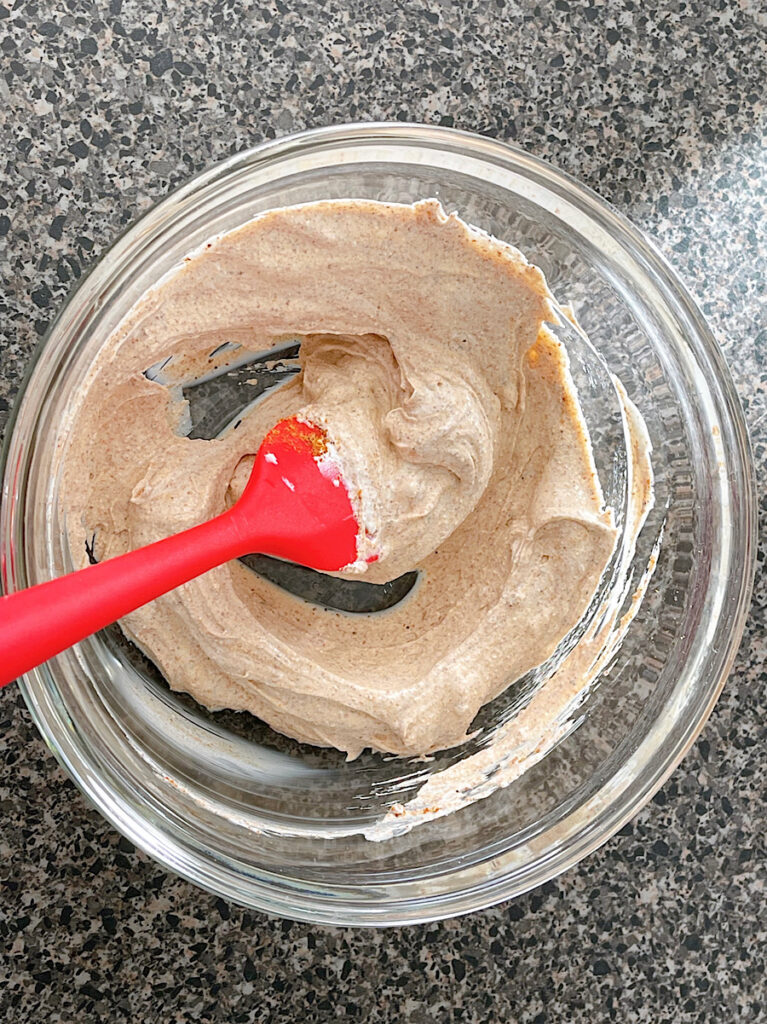 Sour cream mixed with taco seasoning for seven layer dip.