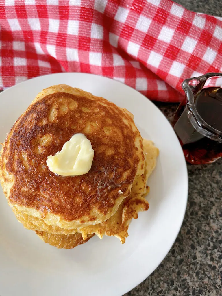 Sour cream pancakes topped with butter.