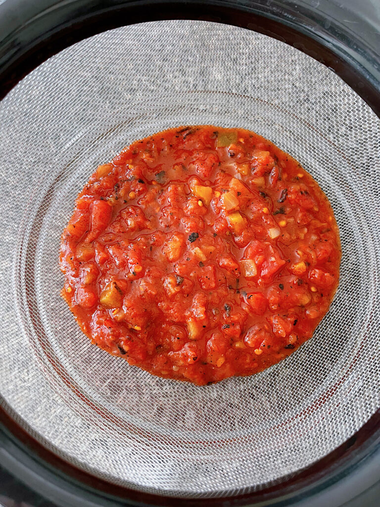 Salsa in a strainer to remove excess liquid.