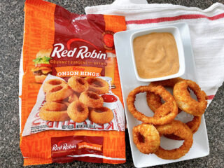 A bag of frozen Red Robin onion rings cooked in an air fryer and campfire sauce.