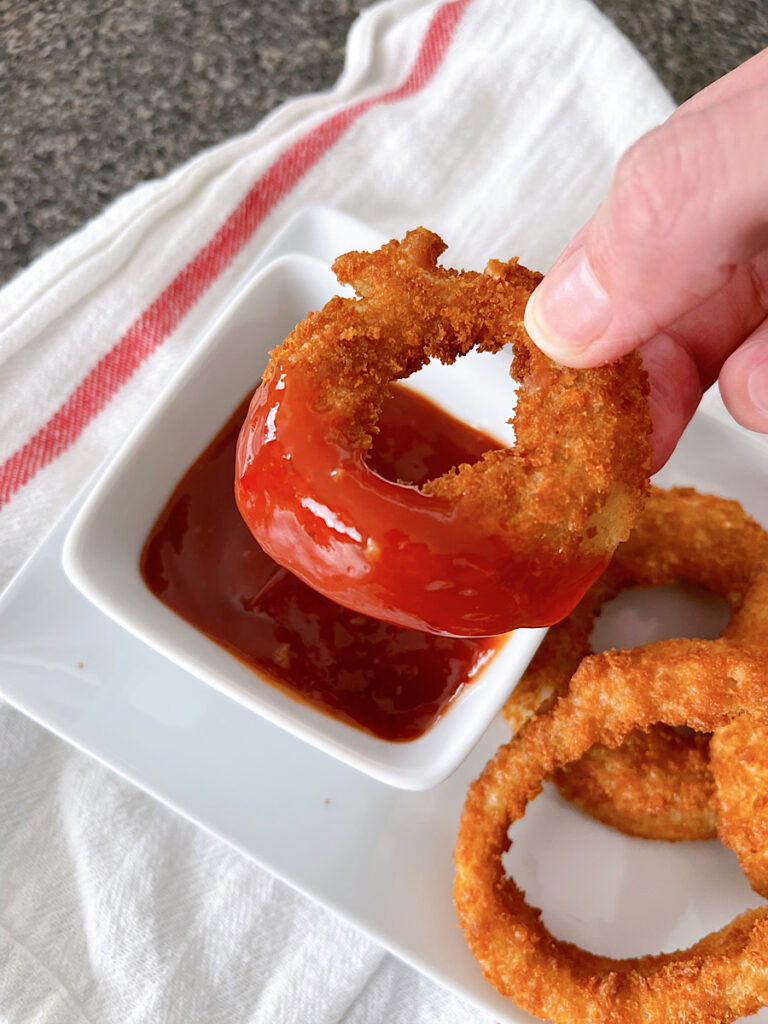 A Red Robin onion ring dipped in spicy ketchup.